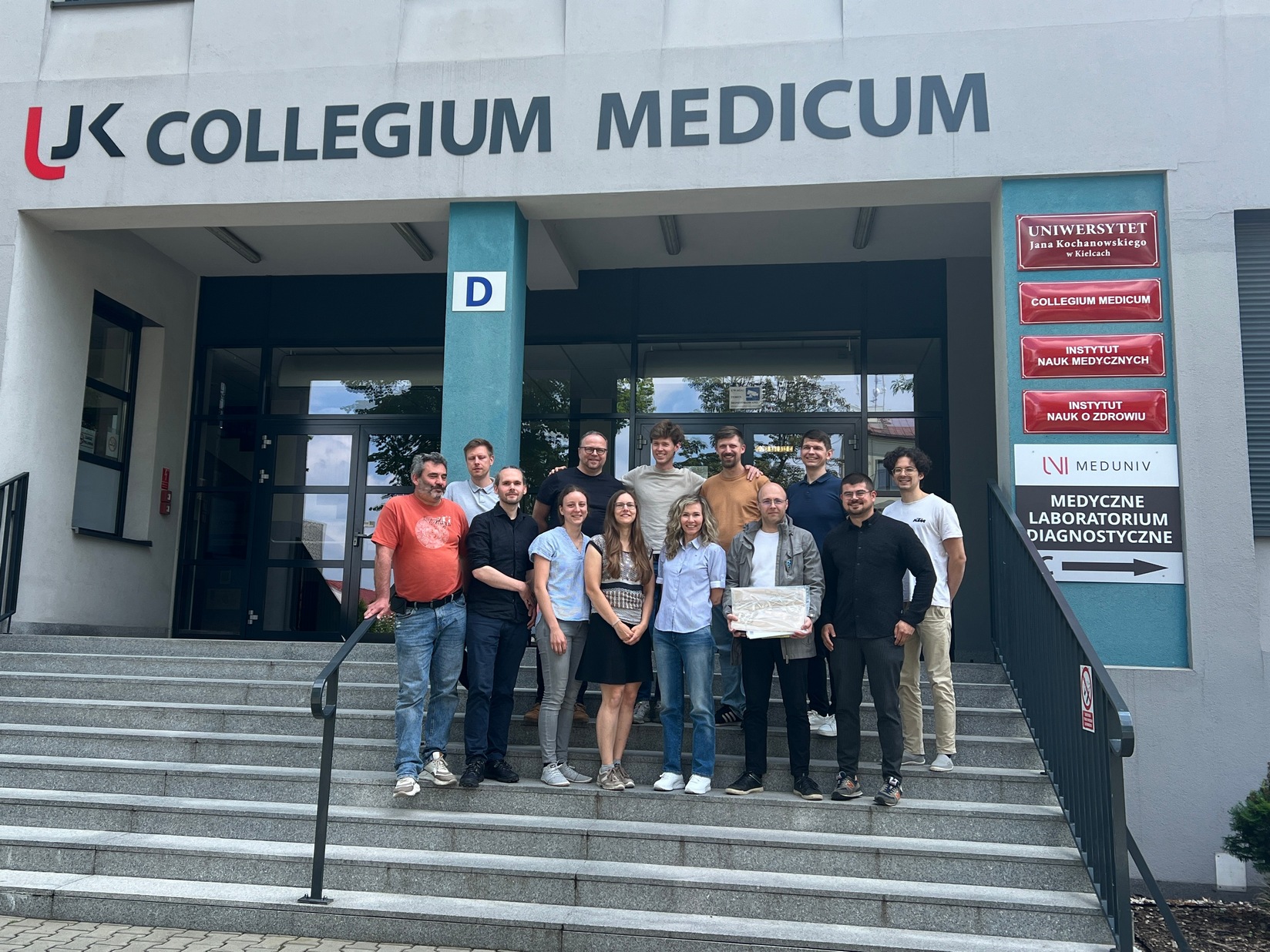 grupa ludzi stoi przed wejściem do Collegium Medicum